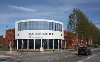 Het gebouw van Driestar Hogeschool, deels wit en deels bruin, aan een kruispunt. 