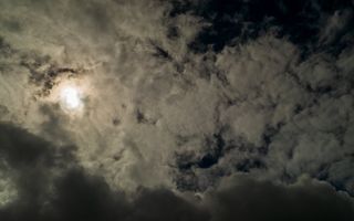 Nachtelijke lucht met wolken voor de maan.