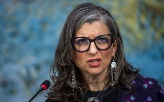 Een vrouw met grijs haar en een bril op. 