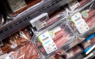Vleesproducten in een winkelschap. Op een verpakking staat het logo van Albert Heijn en de tekst: ”Braadworst met suikerbietenvezel”.