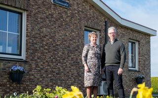 Echtpaar voor gevel met groengeschilderd bord waarop de naam Hammerfest staat.