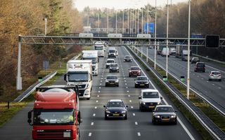 Vrachtauto’s en personenwagens rijden naast elkaar op een driebaanssnelweg.