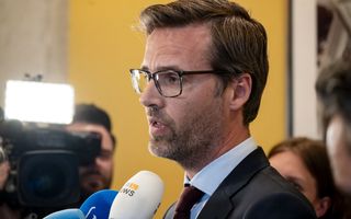 Man in pak staat journalisten te woord.