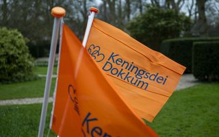 Twee oranje vlaggen met in het blauw de tekst ”Keningsdei Dokkum”.