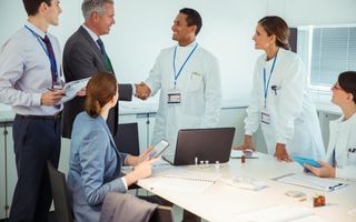 Wetenschappers en zakenmensen in gesprek in een vergaderzaal.
