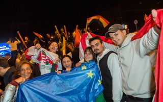 Vrolijke mensen houden een blauwe vlag met gele sterren vast