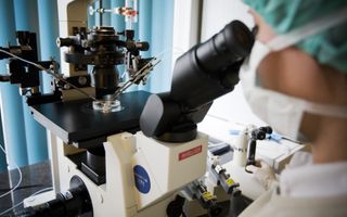 Zwart-wit apparaat in een laboratorium tegen een blauwe achtergrond.