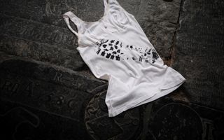 Wit hemd dat bevuild is met de afdruk van een schoen, op de vloer van een kerk.