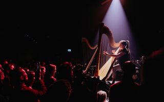 In een vrijwel donkere concertzaal speelt een jonge harpiste. Alleen zij en haar harp worden belicht.