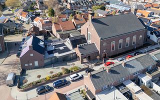 Luchtfoto van een kerkgebouw in een woonwijk.