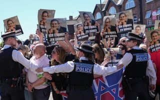 Mensen houden borden omhoog met teksten waarop wordt gesteld dat de Britse premier Keir Starmer de Joden kwaad doet. 