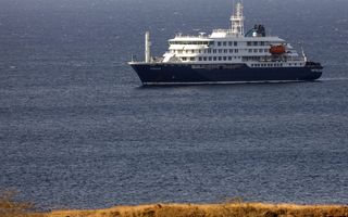Een blauw-wit schip ligt in een blauwe zee.
