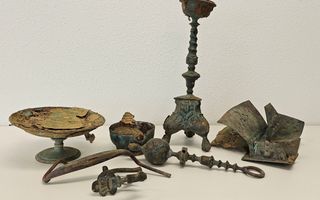 Oude metalen voorwerpen, zoals een schaal en een kaarsenstandaard.