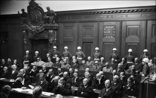 Zwart-witfoto van mannen die in houten bankjes zitten. 