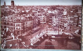 Stadsgezicht met monumentale panden. Op de voorgrond een deel van een oude haven met schepen.