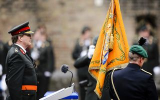 Een koster hijst de Nederlandse vlag op een kerktoren.