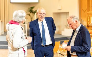 Twee mensen en een vrouw in gesprek met elkaar.