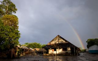 Een regenboog boven een school in het regenwoud