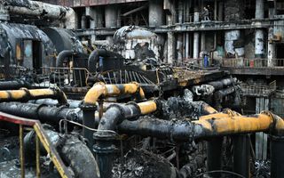 Arbeiders ruimen puin in een verwoeste energiecentrale van de Oekraïnse energieleverancier DTEK. beeld AFP, Genya Savilov
