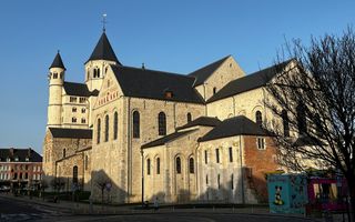 Een oude kerk van lichte stenen, met torens.