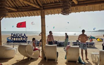 Zicht op zee vanuit strandtent. De Marokkaanse vlag (rood met groene ster) wappert fier in de wind.