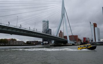 De Erasmusbrug in Rotterdam. Een bootje vaart voorbij. 