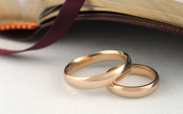 Twee trouwringen bij een geopende Bijbel.