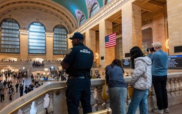 Mensen kijken vanaf een verhoging uit op de hal van een station.