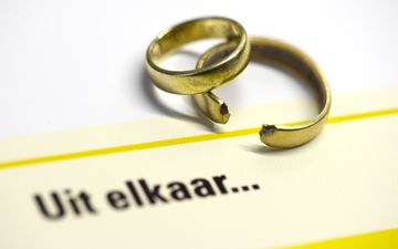 Twee trouwringen waarvan er een gebroken is. Daaronder staan de woorden ”Uit elkaar…”.
