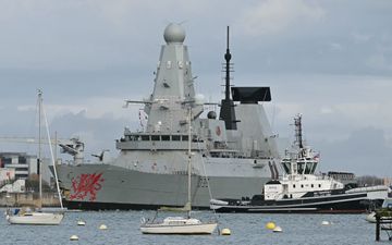 Een marineschip ligt in het water. 