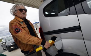 Een man met grijs haar is aan het tanken.