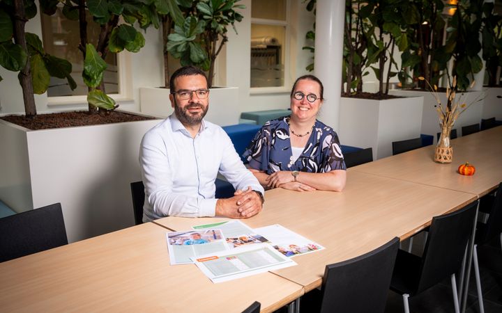 Man met baard en bril en een vrouw met een bril zitten naast elkaar aan een tafel waarop de lesmethode Wonderlijk gemaakt ligt.