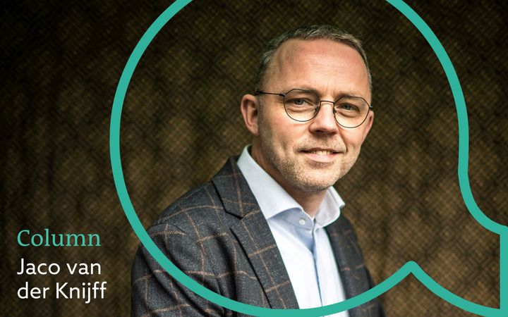 Man met bril kijkt glimlachend in de camera.