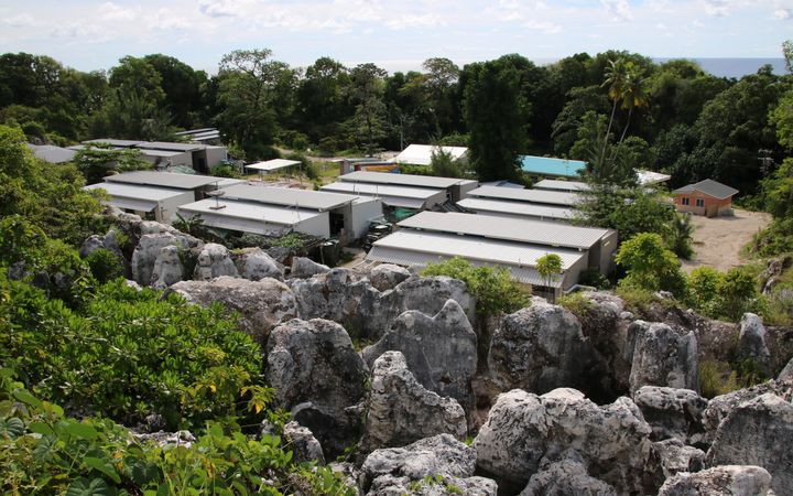 Hutten staan tussen palmbomen. 