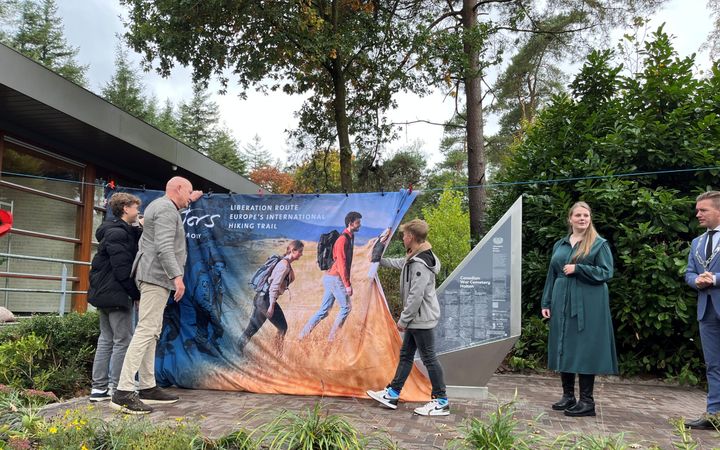 Jongen schuift gordijn opzij