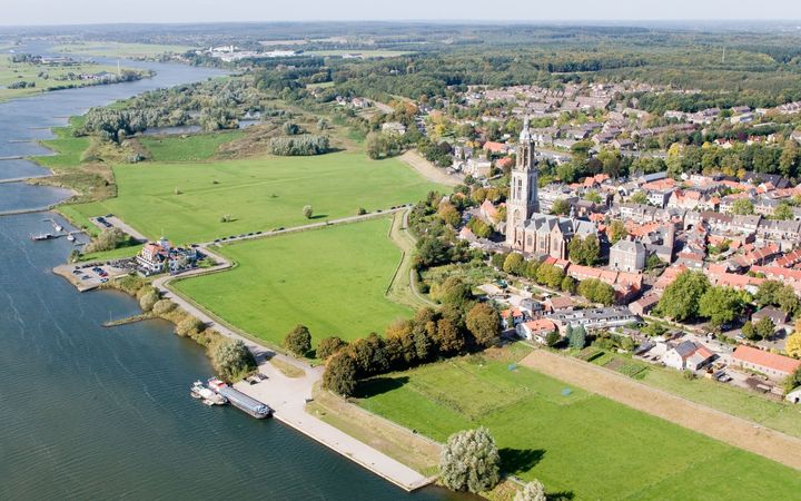 Stad aan een rivier met grote gotische kerk.