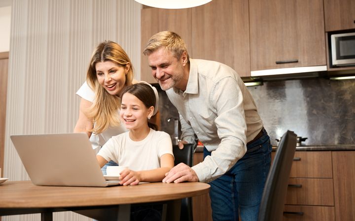 Ouders kijken mee op de laptop van hun dochter