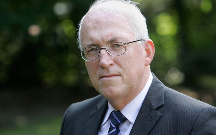 Portretfoto van oudere man, brildragend, grijs colbert.