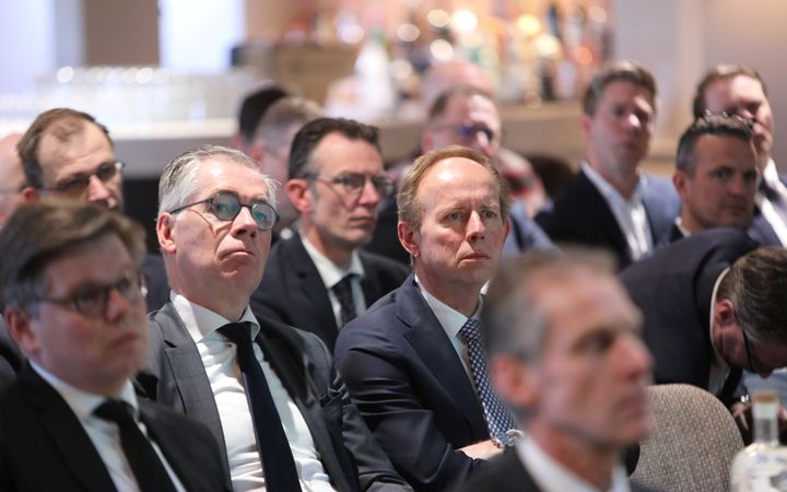 Detailopname van enkele mannen die aan het luisteren zijn.