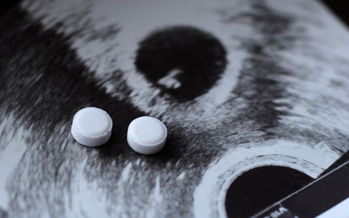 Twee witte pilletjes op de foto van een echo. 