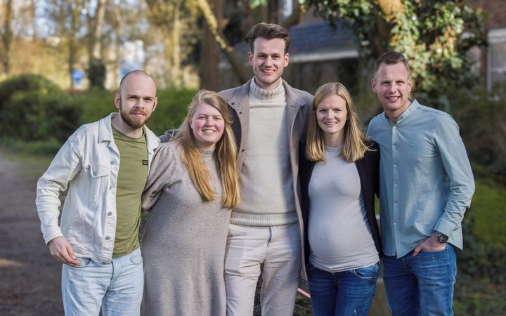 Vijf twintigers staan gearmd op een rij.