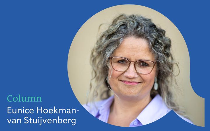 Vrouw met donkerblonde krullen en bril.