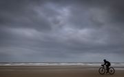 Een deelnemer fietst over het strand tijdens een strandrace bij Egmond aan Zee. beeld ANP, Koen van Weel