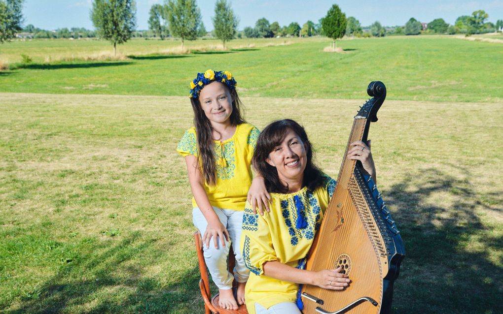 Hattem - Natalia  Slobodianuk met haar jongste dochter Daniela Ruth (8) uit Oekraïne. Het instrument is een Bandura, een Oekrains snaarinstrument. beeld Sjaak Verboom