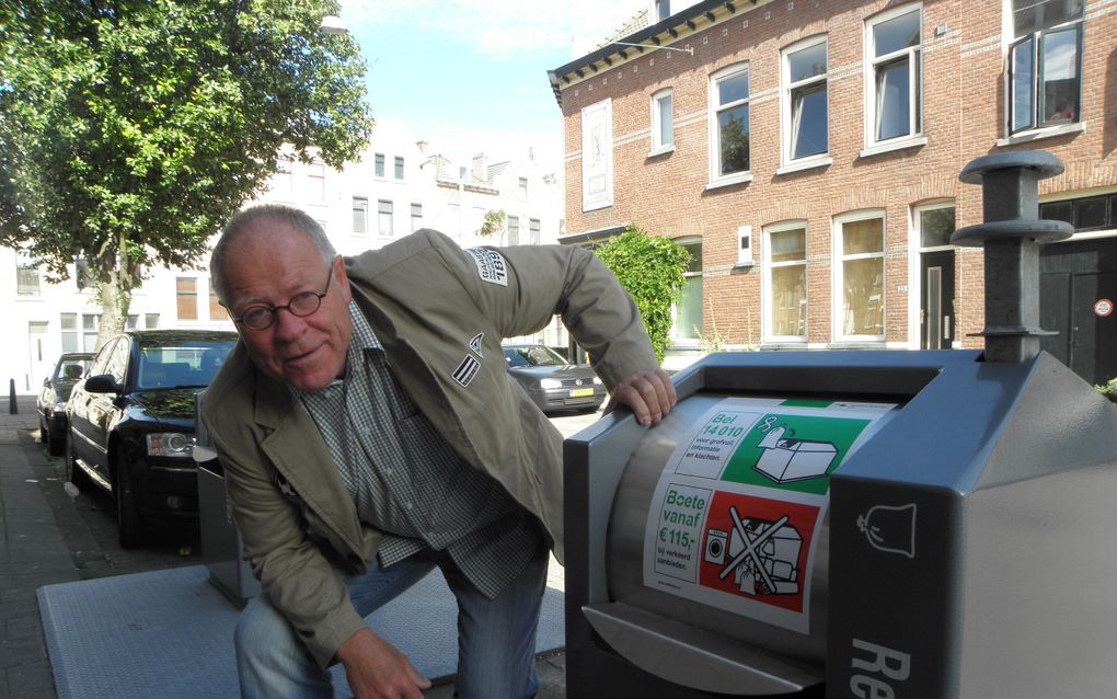 Dries Mosch naast een vuilcontainer in de 3e Dwarsstraat in Rotterdam. „Normaal gesproken is het hier een bende met rondslingerend vuil. Nu ik de vuilste deelgemeente van Rotterdam de Gouden Kakkerlak wil geven, is het hier helemaal opgeruimd. Mooi toch?”