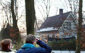 PUTTEN - Rechter mr. H. M. Poelman (l.) en mr. Vellinga, voorzitter van de strafkamer van het gerechtshof in Leeuwarden, tijdens de schouw van de Puttense moordzaak. Op de achtergrond het met zwart plastic van de nieuwsgierige buitenwereld afgeschermde hu