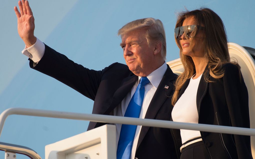 Donald Trump en Melania Trump voor vertrek naar Parijs, waar zij op uitnodiging van de Franse president Macron aanwezig zullen zijn bij de viering van de Franse nationale feestdag. beeld AFP