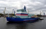 De Russische nucleair aangedreven ijsbreker Arktika verlaat de haven van Sint Petersburg voor zijn eerste vaart naar Moermansk. Het schip moet op termijn een vaarroute binnen de poolcirkel creeëren. beeld AFP, Olga Maltseva