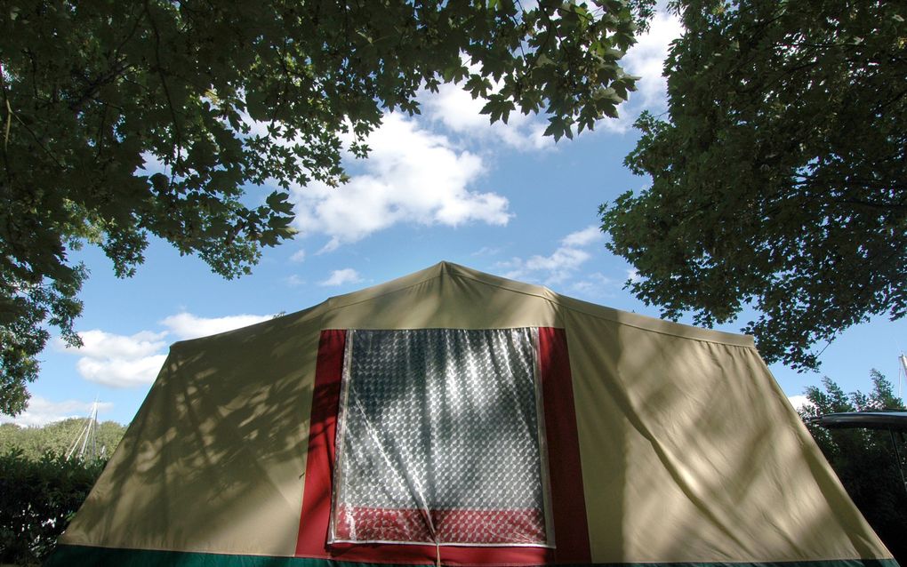 Vouwwagen, schaduw en blauwe lucht op een camping in Frankrijk. Foto ANP