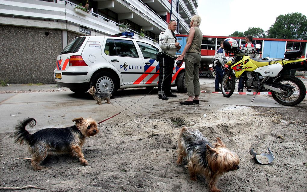 Een agent ondervraagt een vrouw na een burenruzie in Amsterdam. Foto ANP